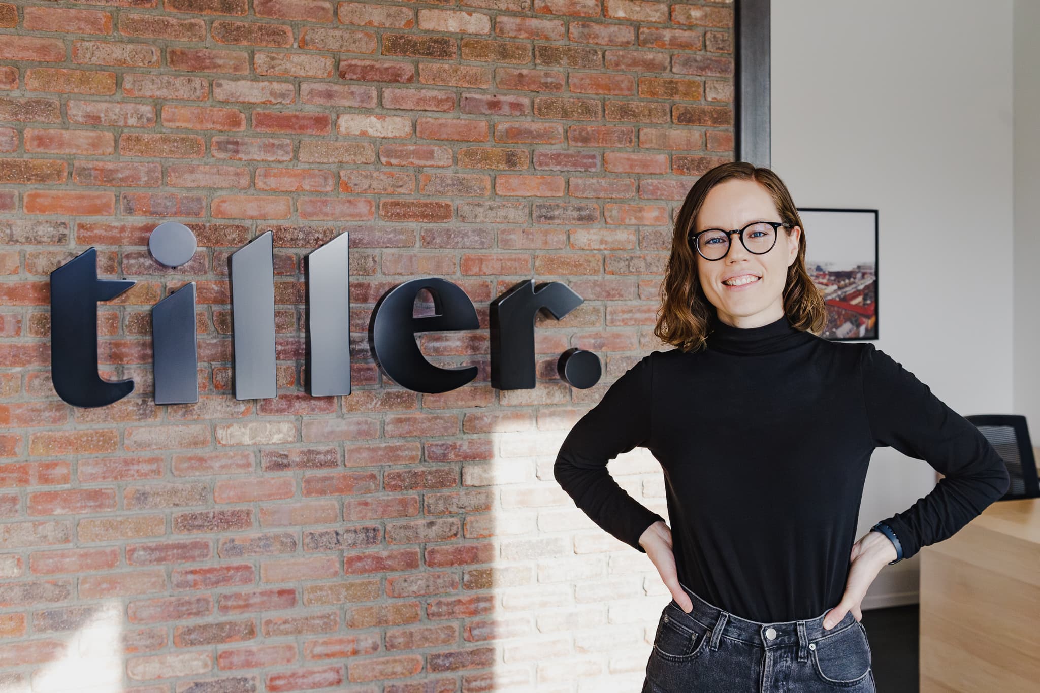 Tiller founder standing in front of the Tiller office sign